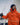 A man in a boat with a waterproof jacket, waterproof salopettes, navy beanie and sailing gloves