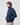 Close-up side view of navy jacket with raised collar, sleeve crest logo, and grey reflective detail on back of collar.