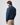 Rear angled view of man in navy jacket paired with beige trousers, showing collar branding and ribbed hem.