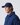 Side profile of a model wearing a baseball cap and button-up jacket, featuring an embroidered sleeve patch.