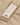 Close-up of a Henri-Lloyd branded fabric label with a Union Jack flag, covered in water droplets on the beige jacket fabric.
