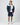 Navy and cream insulated jacket styled with navy shorts and white trainers in studio.