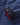 Close-up of the jacket’s cuff featuring black corduroy trim, snap fasteners and a glimpse of the red lining.