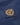 Close-up of the embroidered Henri-Lloyd crest patch in gold thread on the navy fabric.