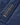 Close-up of the Henri-Lloyd label stitched to the jacket, featuring gold embroidered text and the Union Jack flag on navy fabric.