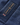Close-up of the navy jacket’s outer fabric with water droplets beading on the surface, alongside a Henri-Lloyd branded patch with a Union Jack flag.