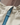 Close-up of branded Henri-Lloyd zip puller and light blue teeth on the Foremost Shell Jacket in Washed Teal.
