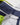 Close-up of the jacket’s shoulder seam, showing white, navy, and fluorescent yellow panels with adjustable hood cord detail.