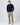 Navy cable knit sweater paired with beige sailing trousers.