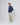 Model in navy jacket paired with beige chinos and light blue sneakers, standing in studio with hands in pockets.