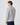 Rear view of light grey cable knit sweater with ribbed hem and cuffs.